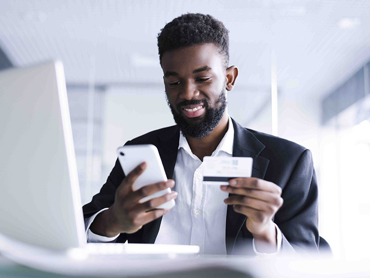 Happy man pays bill on mobile phone