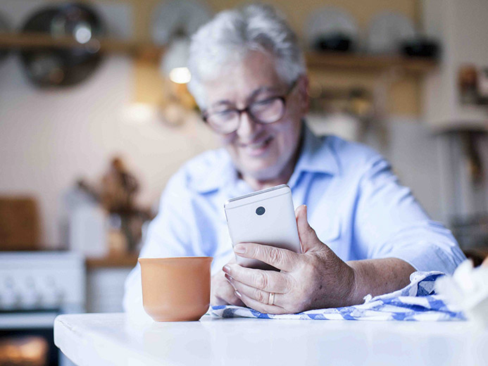 Happy man types on mobile phone